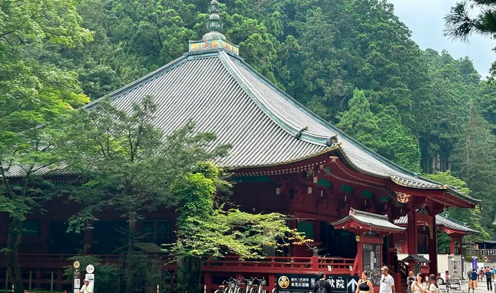 Templo Rinno-ji en Nikko, Japón, rodeado de árboles y con su icónica arquitectura de madera y techo ornamentado.