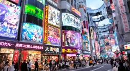 Vista realista de Akihabara en 2025 con luces de neón, anuncios de anime y tiendas de tecnología en Tokio
