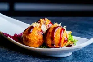 Descubre la historia de los takoyaki y aprende a preparar estas deliciosas bolas de pulpo japonesas con nuestra receta paso a paso.